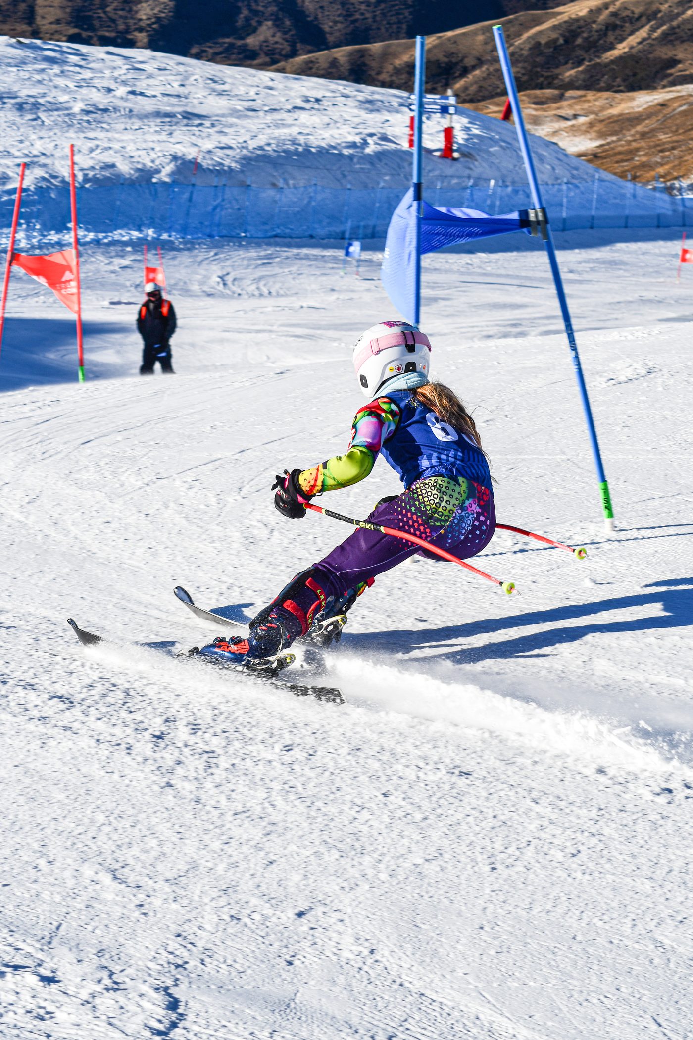 Briar dropping into the course at Cardrona, mountains behind